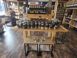 a wooden table with jars and glasses on it in a store
