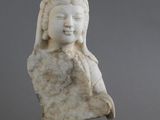 une statue en marbre blanc représentant une femme coiffée d'un chapeau, avec deux figurines à côté