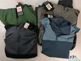 three pairs of men ' s jackets with tags on them sitting on a table