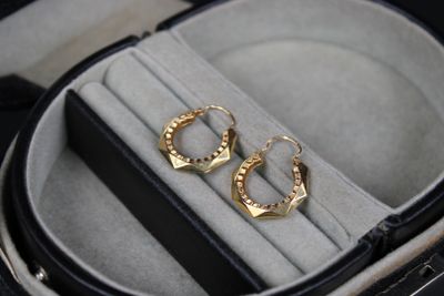 deux paires de boucles d'oreilles dans un écrin posé sur une table