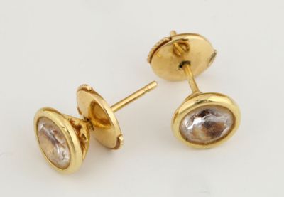 une photo d'une paire de boucles d'oreilles en or ornées d'une pierre facettée