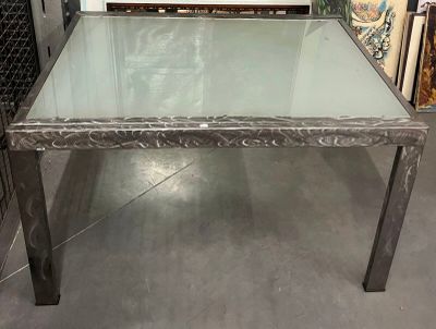 une table en verre avec des pieds en métal et un plateau en verre