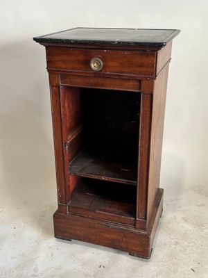 une vieille armoire en bois avec un plateau en marbre, posée sur un sol blanc