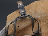 a brown hat with a leather strap on top of it