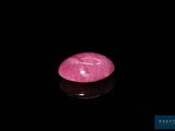 un gros plan d'une pierre rose sur une surface noire