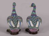 pair of colorfully painted ceramic ducks on stand on grey background