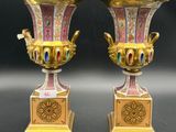une paire de vases dorés et roses posés sur une table