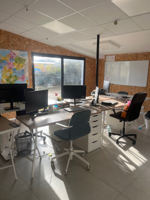 une image représentant un bureau avec de nombreux bureaux et ordinateurs