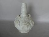 a white vase with a design on it on a table