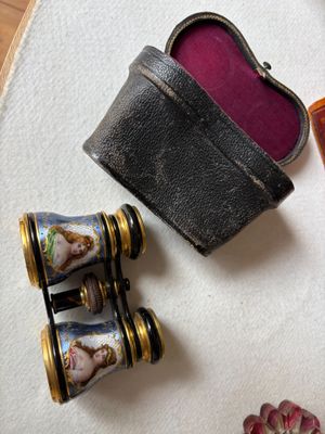 une petite boîte sur laquelle figure une image, à côté d'une paire de jumelles