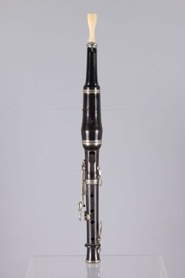 an image of a black and silver clarinet on a clear surface