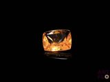 a close up of a yellow diamond on a black surface