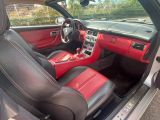 l'intérieur d'une voiture avec des sièges en cuir rouge et des garnitures en cuir noir