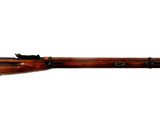 Le fusil est posé sur un fond blanc et est prêt à l'emploi.