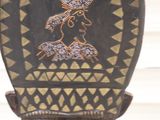 a black and gold mask on a stand in front of a white wall