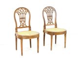 pair of wooden chairs with upholstered back and seat cushions