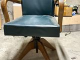 a blue leather chair with wooden legs in a room