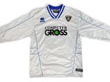 Le t-shirt est blanc et bleu, avec un logo vert dessus.