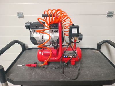 an image of a red air compressor on a cart