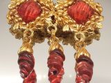 une paire de boucles d'oreilles rouges et dorées exposées dans une vitrine