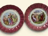 two plates with a painting on them are sitting on a table