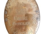 une plaque en laiton portant une inscription sur fond blanc