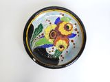 a plate with flowers painted on it on a white surface