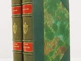 two green books sitting on top of each other on a white surface