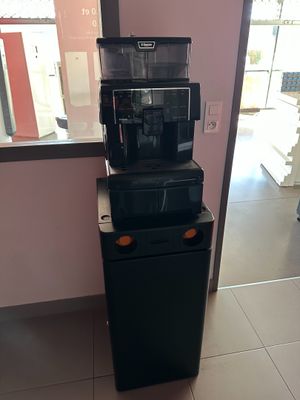 a coffee machine on top of a refrigerator in a room
