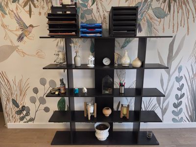 une étagère noire sur laquelle sont disposés de nombreux objets divers