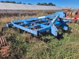 une charrue bleue au milieu d'un champ