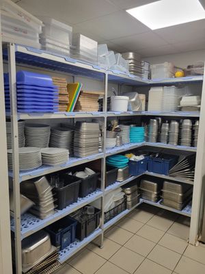 many plates and pans on the shelves in the kitchen