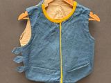 un gilet bleu accroché à un cintre sur un mur