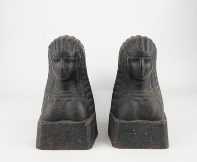 pair of black stone sphinx statues of a woman and a man