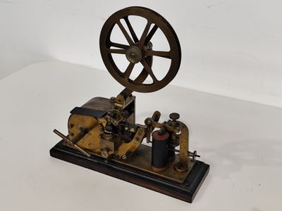 une vieille maquette de machine à vapeur posée sur une surface blanche