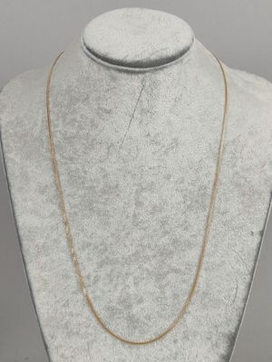 a gold chain necklace on a mannequin neck