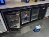 un petit réfrigérateur avec deux bouteilles d'eau posées sur le plan de travail