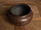 a brown bowl sitting on a wooden floor on the floor