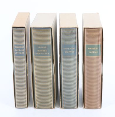 quatre livres sont alignés sur une surface blanche