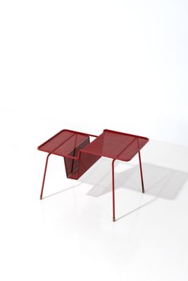 a small red table with a magazine holder on it