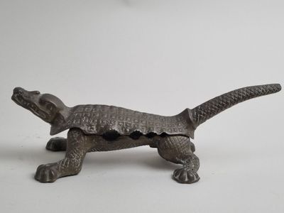 a small statue of a lizard on a white surface