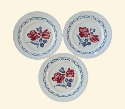 trois assiettes blanches ornées de fleurs rouges sur un fond blanc