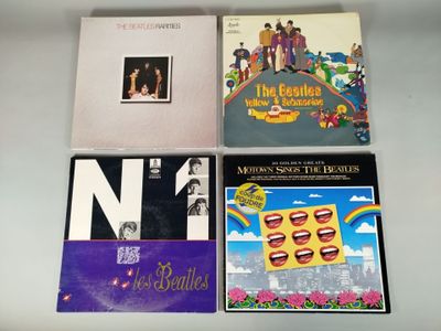 four beatles albums, including the beatles album, are on a table