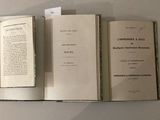 trois livres ouverts posés sur une table
