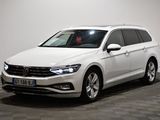 La Volkswagen Passat blanche est garée dans une pièce dont le sol est à carreaux.