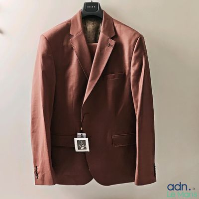 un costume marron suspendu à un cintre accroché au mur