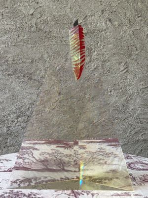 a red and white kite flying over a table