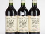 trois bouteilles de vin sont alignées sur une surface blanche