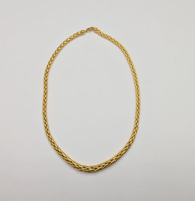 a gold rope necklace on a white background