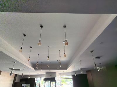 les nombreuses lampes qui sont suspendues au plafond dans cette pièce